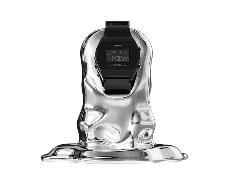 En digital klocka av märket Casio x GRAGG, modell LW-204GRAGG-1BDF, placerad på ett skulpturalt silverfärgat stativ mot en vit bakgrund.