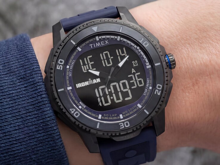 Svart Timex Ironman Adrenaline ana-digi-klocka med mörkblå armband och blå krona, avbildad på en handled.