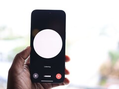 En hand som håller en smartphone med ett gränssnitt för röstassistenten på skärmen