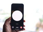 En hand som håller en smartphone med ett gränssnitt för röstassistenten på skärmen
