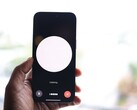 En hand som håller en smartphone med ett gränssnitt för röstassistenten på skärmen