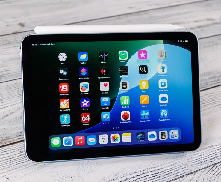 Frontvy av en iPad mini med Apple Pencil vilande ovanpå, som visar startskärmen när den är placerad på en träyta. (Bildkälla: Notebookcheck)