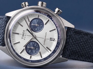 Timex Marlin Jet Chronograph fotograferad mot en mörk bakgrund, där man ser det välvda glaset, takymeterringen, den konkava urtavlan, kronografens underurtavlor och den retrofuturistiska designen på boetten.