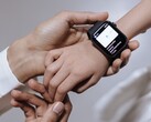 En vuxen hand som sätter fast en smartklocka på ett barns handled