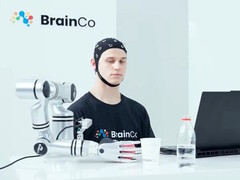 En användare av BrainCos teknik för tankestyrning som mekaniskt tar tag i ett äpple enbart med hjälp av tanken.