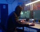 Generisk hackare vid en arbetsstation med dubbla skärmar som utför en attack mot en leverantörskedja.