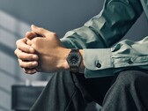 En Citizen Eco-Drive One AR5065-54W på handleden, med en skogsgrön och svart urtavla, detaljer i roséguld och ett ultratunt armband med svart beläggning.