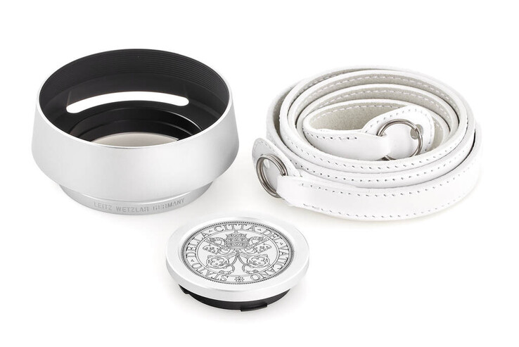 Ett motljusskydd, en kamerarem och ett graverat linslock medföljer Leica "Pope Francis" M-A kit. (Bildkälla: Leica)