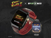 Spelklockan Street Fighter II: My Play Watch med ett rött armband, detaljer med guldfinish och en andra klockdisplay, mot en mörk, texturerad bakgrund.