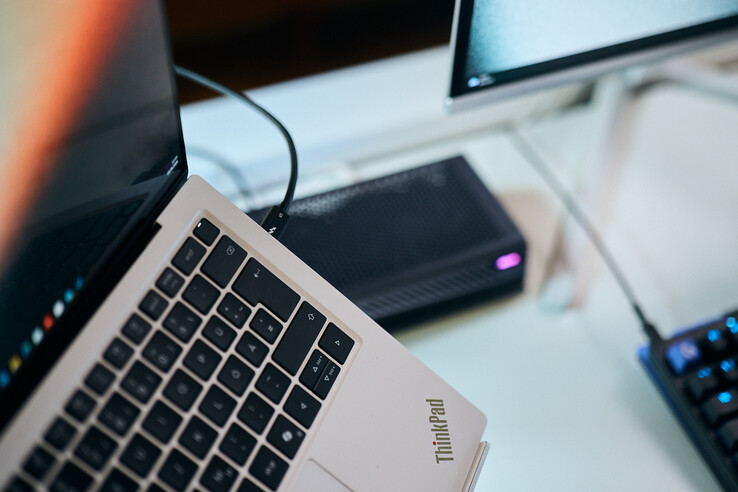 Närbild på en Thunderbolt 5-kabel ansluten till sidoporten på en Lenovo ThinkPad X9-bärbar dator med Aorus eGPU i bakgrunden.