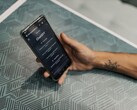 Hand som håller en smartphone med ChatGPT-appen öppen ovanför ett mönstrat bord