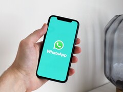 Hand som håller en smartphone med WhatsApp-appen öppen