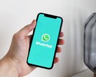 Hand som håller en smartphone med WhatsApp-appen öppen