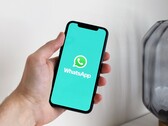 Hand som håller en smartphone med WhatsApp-appen öppen