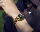 Seiko Presage Classic x Tradman’s Bonsai-klocka på en handled, med guldfärgat boett och armband samt en mörkgrön urtavla.