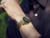 Seiko Presage Classic x Tradman’s Bonsai-klocka på en handled, med guldfärgat boett och armband samt en mörkgrön urtavla.