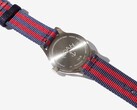 Baksidan av klockan Noah x Timex MK1 Anchor med graverad bakboett i rostfritt stål och armband i marinblått och rött tyg.