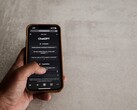 Hand som håller en smartphone som visar ChatGPT-gränssnittet ovanför en grå stenyta