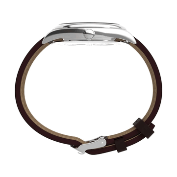 Sidoprofil av Timex Legacy Day and Date som framhäver dess polerade boett i rostfritt stål, räfflade krona, böjda bandhorn och bruna läderarmband mot en vit bakgrund.