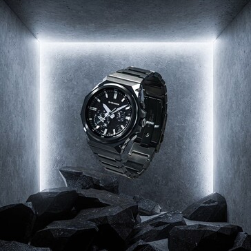 G-Shock GST-B1000BD-1A hänger ovanför mörka stenar i ett utställningsutrymme i betong och framhäver sin konstruktion i svart rostfritt stål.