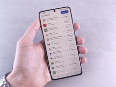 En hand håller en smartphone där en lista med uppdateringar visas på skärmen.