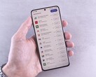 En hand håller en smartphone där en lista med uppdateringar visas på skärmen.
