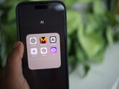 Hand som håller en smartphone med en mapp full av AI-appar på skärmen