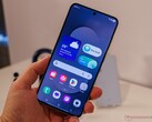 Bilden visar en Galaxy S25 FE som hålls av en recensent