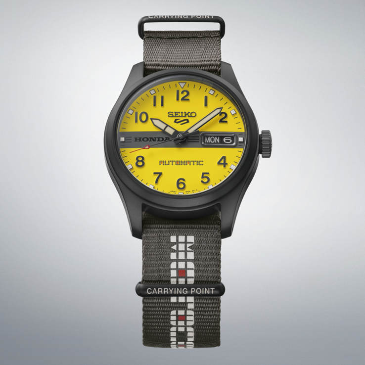 Framsidan av Seiko 5 Sports Field x Honda Motocompo Limited Edition med gul urtavla, svart Honda-logotyp mitt på urtavlan och grå nylonrem.