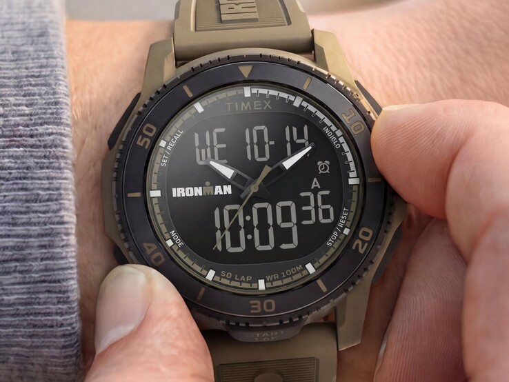 En sandfärgad Timex Ironman Adrenaline ana-digi-klocka som visas på en handled, med en svart ram och en synlig digital display.