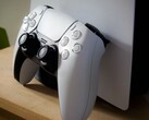 En bild av en PlayStation 5 DualSense-handkontroll som lutar mot en PS5-konsol