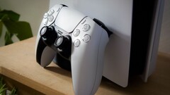 En bild av en PlayStation 5 DualSense-handkontroll som lutar mot en PS5-konsol