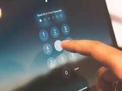 Fingret knappar in en PIN-kod på ett sifferfält på skärmen