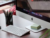 En iMac på ett skrivbord med macOS-docken synlig på skärmen och ett Apple-tangentbord framför