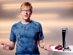  Mark Cerny under ett PlayStation-event, sittande bredvid en PS5-konsol och DualSense-kontroller. (Bildkälla: Sony Interactive Entertainment)