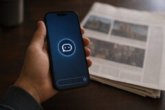 En hand håller en smartphone med en chatbot-ikon, och bredvid den ligger en tryckt tidning.