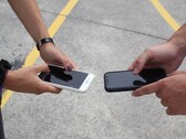 Två personer som håller två smarttelefoner sida vid sida vid en överlämning