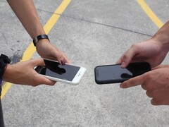 Två personer som håller två smarttelefoner sida vid sida vid en överlämning