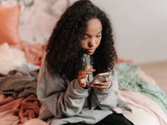 Tonåring som använder en smartphone på en säng, symbolisk bild för ChatGPT for Teens och föräldrakontroller