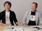 En skärmdump av Shigru Miyamoto och Tezuka Takashi med t-shirts från 30-årsjubileet av Super Mario Bros