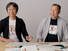 En skärmdump av Shigru Miyamoto och Tezuka Takashi med t-shirts från 30-årsjubileet av Super Mario Bros