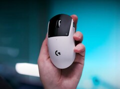 Logitech G Pro X2 Superstrike gamingmus i en hand på en blå bakgrund
