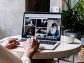 Person som skriver på en bärbar dator på ett kafé, ett webbläsarfönster med flikfält och adressfält på skärmen