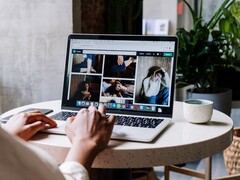 Person som skriver på en bärbar dator på ett kafé, ett webbläsarfönster med flikfält och adressfält på skärmen