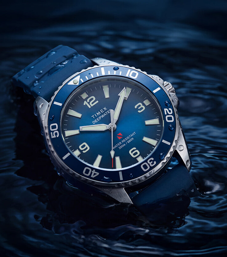 Timex Deepwater Arctic 200 med en blå urtavla med gradvis färgskiftning och ett matchande blått HNBR-gummiarmband, fotograferad delvis nedsänkt i vatten.
