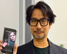 Hideo Kojima visar en affisch för Physint på sin telefon