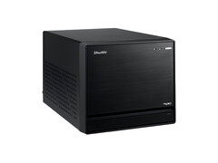 Bilden visar en vy rakt framifrån av Shuttle XPC Mini PC, som ser ut som en svart kub med en minimal design. 