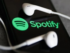 En bild som visar hörlurar på en telefon med Spotify-logotypen. (Bildkälla: Jakub Porzycki/NurPhoto - Getty Images)
