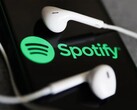En bild som visar hörlurar på en telefon med Spotify-logotypen. (Bildkälla: Jakub Porzycki/NurPhoto - Getty Images)