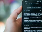 Någon som använder sin telefon för att hitta en restaurang med hjälp av Gemini